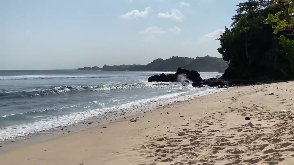 Indahnya Bukit Hijau dan Laut Biru Menyatu di Pantai Ngopet Malang